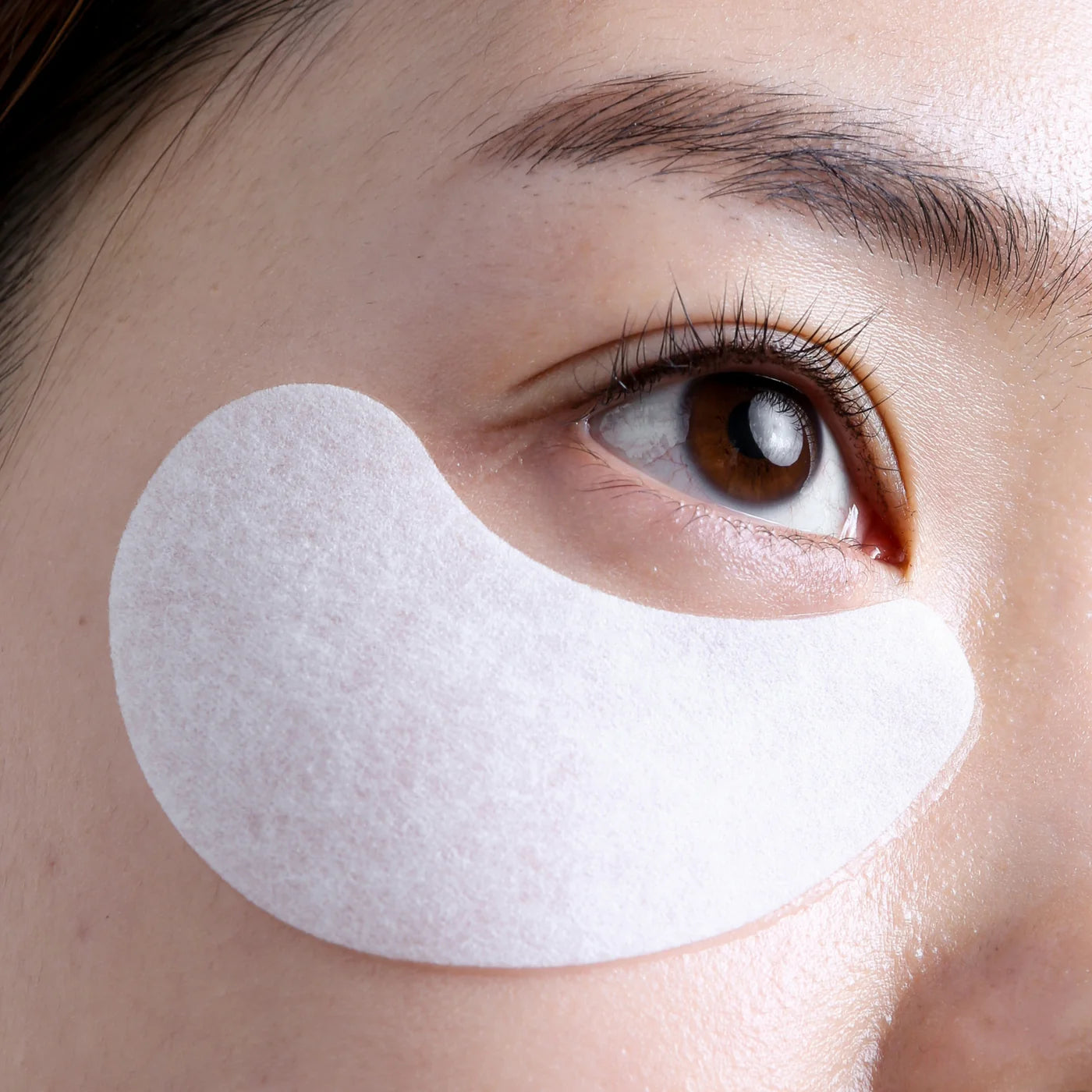 Model applying Le Mieux TGF-β Eye Firming Mask to reduce dark circles and puffiness.