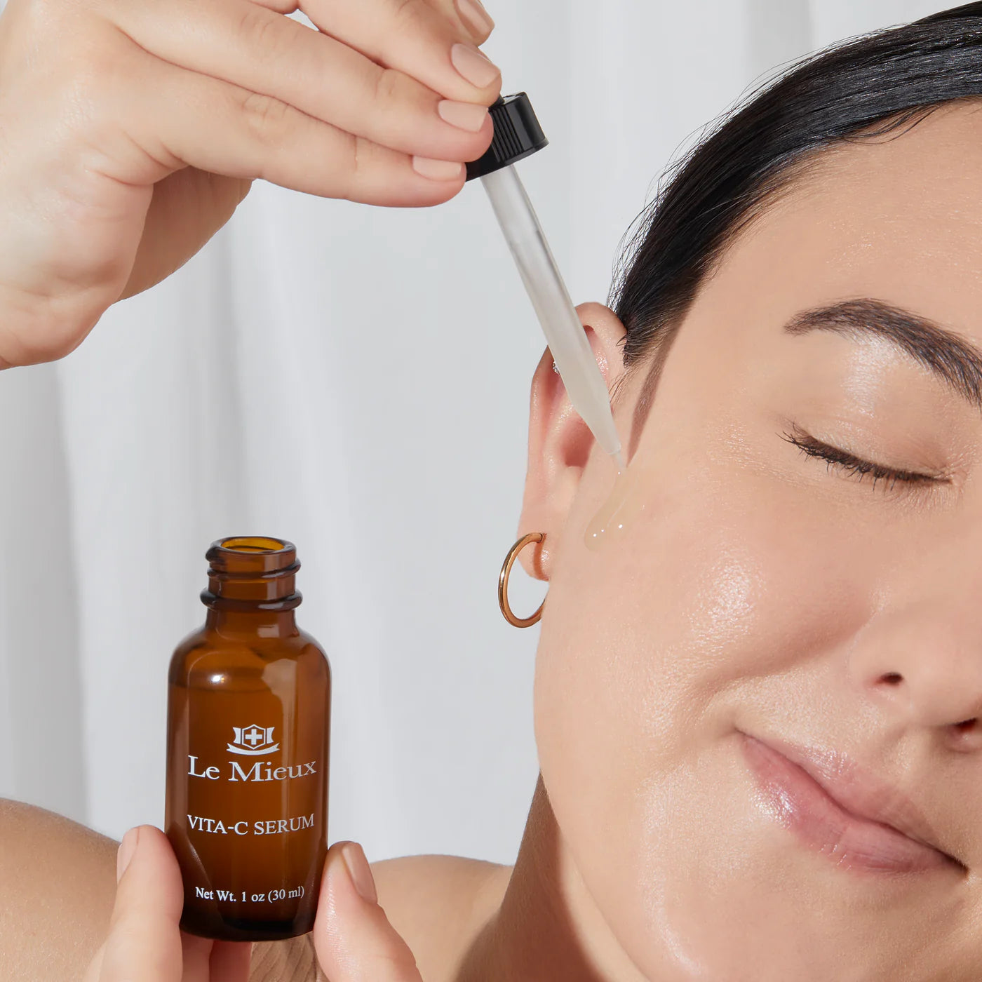 Model applying Le Mieux Vitamin C Serum to reveal brighter, smoother, and more luminous complexion.