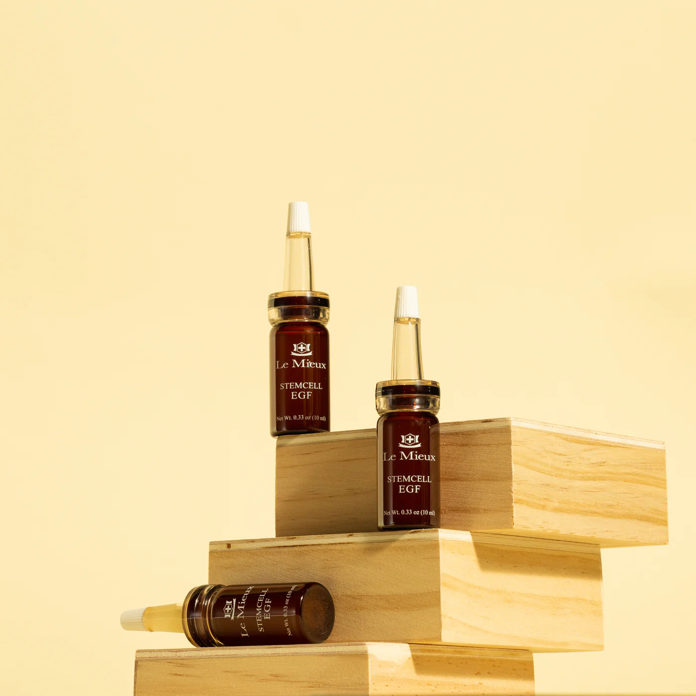 Le Mieux Stem Cell EGF ampoules displayed on wooden blocks for luxury skincare.